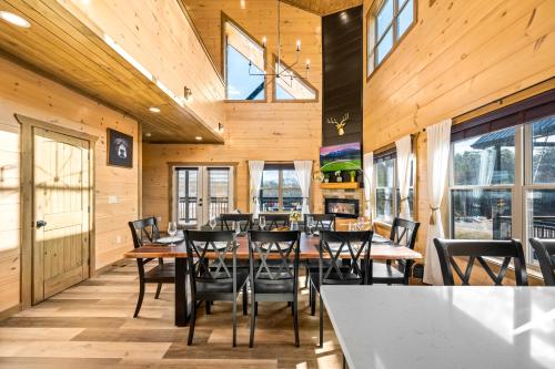 a dining room with wooden walls and tables and chairs at SmokiesBoutiqueCabins would love to host you at our NEW cabin! 3 King Suites, Indoor Pool, Game Room, Lounge with 75" TV! Close to Dollywood and the Parkway! in Pigeon Forge