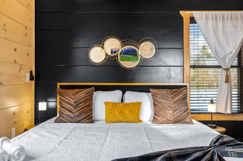a bedroom with a bed with a black headboard at SmokiesBoutiqueCabins would love to host you at our NEW cabin! 3 King Suites, Indoor Pool, Game Room, Lounge with 75" TV! Close to Dollywood and the Parkway! in Pigeon Forge