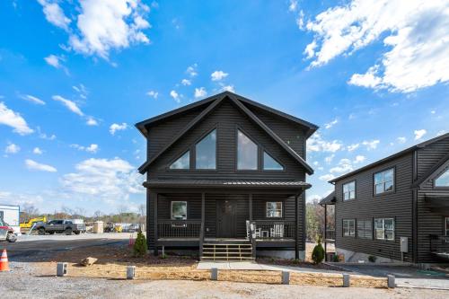a black house with a gambrel roof at SmokiesBoutiqueCabins would love to host you at our NEW cabin! 3 King Suites, Indoor Pool, Game Room, Lounge with 75" TV! Close to Dollywood and the Parkway! in Pigeon Forge