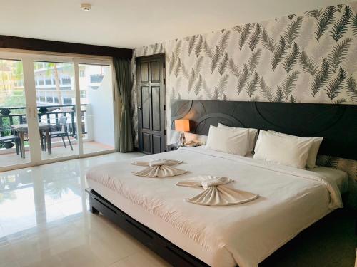 a bedroom with a large bed with two pillows on it at Pattawia Resort & Spa, Pranburi in Pran Buri