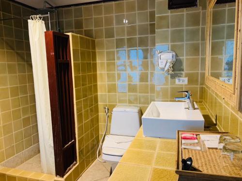 a bathroom with a white toilet and a sink at Pattawia Resort & Spa, Pranburi in Pran Buri