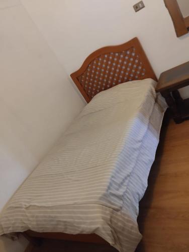 a bed in a bedroom with a wooden headboard at Amatista house in Copiapó