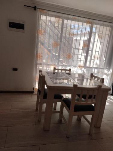 a table and chairs in a room with a window at Amatista house in Copiapó