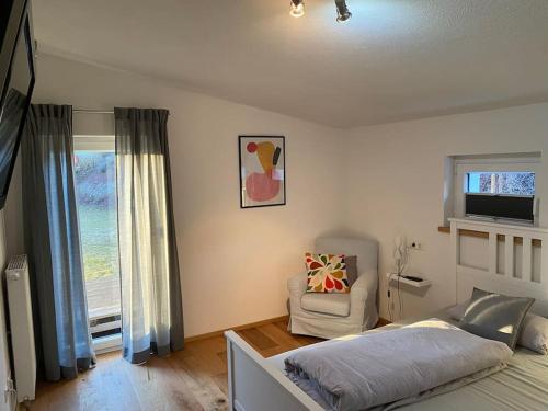 a bedroom with a bed and a chair and a window at Schönes und gemütliches Haus in mitten der Natur in Schabenhausen