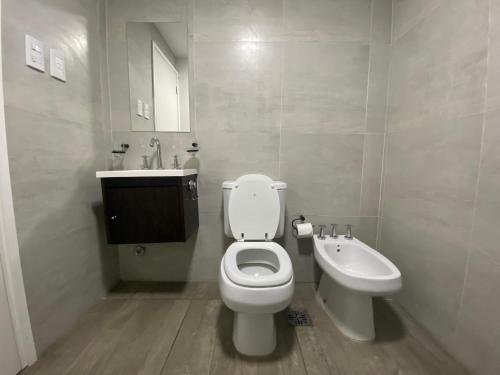 a white bathroom with a toilet and a sink at Andén 7 3/5 in Salta