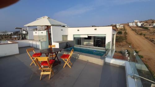 a balcony with a table and chairs and a swimming pool at CASA DE PLAYA Durante todo el año in Punta Negra