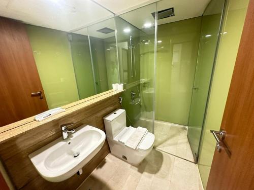 a bathroom with a toilet and a sink and a shower at Sky Suites KL City Center in Kuala Lumpur