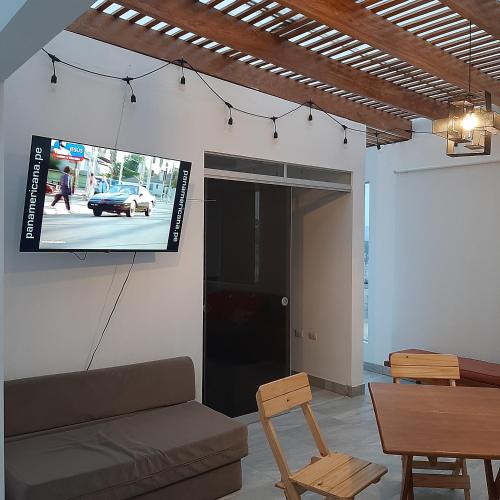a living room with a couch and a tv on a wall at CASA DE PLAYA Durante todo el año in Punta Negra