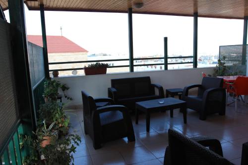 a room with chairs and tables and windows at Pilgrim's Guest House in Madaba