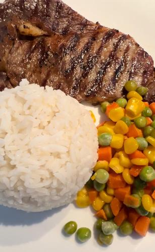 a plate of rice and vegetables and meat at CasaDel Beach House in Mabini