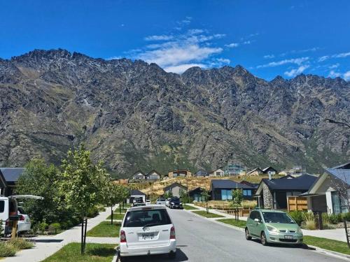 a street in a mountain town with cars parked at Short Drive to Queenstown CBD - Cosy Guesthouse with Private Entrance and King Bed in Frankton