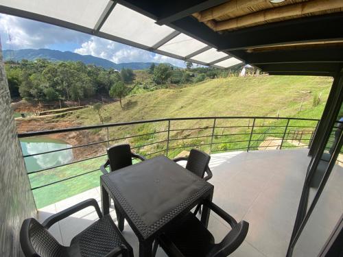 a balcony with chairs and a view of a hill at Springfield Ecoloft- Guatapé in Guatapé