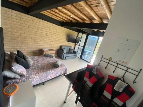 a bedroom with a bed and a chair in a room at Springfield Ecoloft- Guatapé in Guatapé