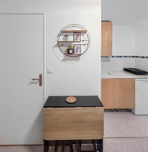 - une cuisine avec une table et un miroir à côté d'une porte dans l'établissement Horizon Marin, à Villers-sur-Mer