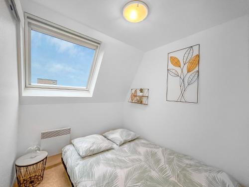 une chambre blanche avec un lit et une fenêtre dans l'établissement Horizon Marin, à Villers-sur-Mer