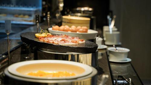 a table with a plate of food and a bowl of eggs at Jeju Bolton Hotel in Jeju