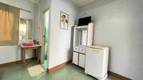 eine Küche mit einem Kühlschrank, einem Tisch und einem Fenster in der Unterkunft Manalo's Lodge and Restaurant in Puerto Galera