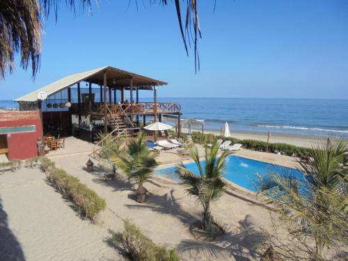 a resort with a swimming pool next to the beach at Balihai Bungalows in Canoas De Punta Sal