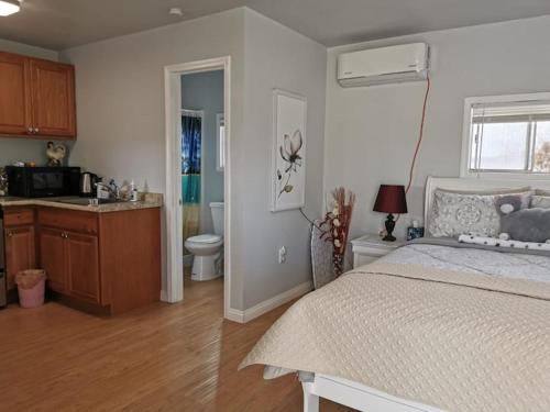a bedroom with a bed and a kitchen with a sink at Sun Cabin #1 Pahrump in Pahrump
