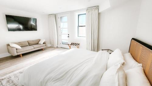 a white bedroom with a bed and a couch at Private Modern Luxury Suite in Historic Stone Home in Washington