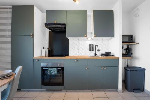 une cuisine avec des armoires bleues et un évier dans l'établissement Le Cookie - 4 pers' - 2 lits - Gare 50m - Parking, à Woippy