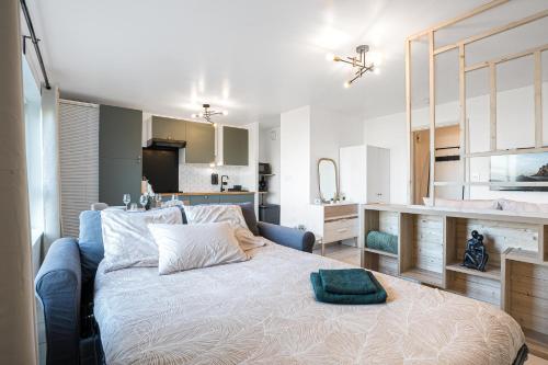 a bedroom with a large bed and a kitchen at Le Cookie - 4 pers' - 2 lits - Gare 50m - Parking in Woippy