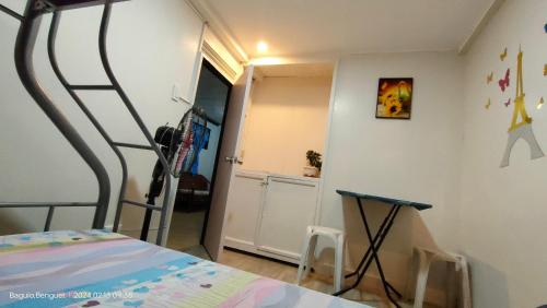 a bedroom with a bed and a table in it at Kochimoto Bed & Bath in Baguio