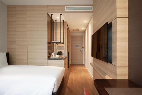 a bedroom with a white bed and a television at Crown Park Hotel Seoul Myeongdong in Seoul