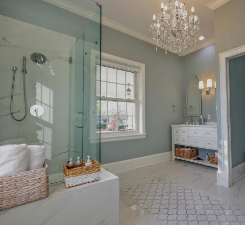 a bathroom with a glass shower and a chandelier at Wood Manor Guest House in Tuscaloosa