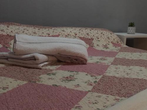 Una cama con edredón y toallas. en Departamento en Posadas, en Posadas