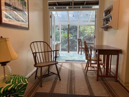 a living room with a table and chairs and a door at Lemon Tree Lanai in Keaau