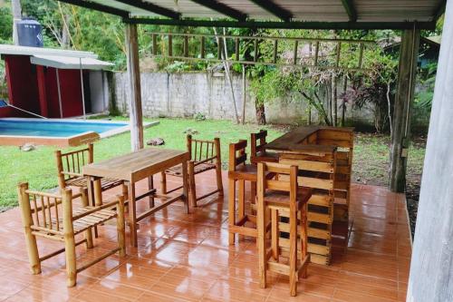 a group of wooden tables and chairs on a patio at Perla del rio tulian in Omoa