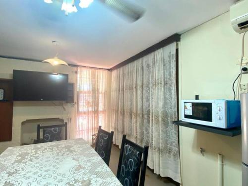 a dining room with a table and chairs and a microwave at Casa Tupungato con Churrasquera in Tupungato