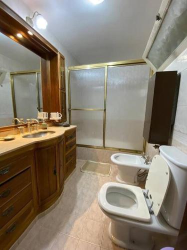 a bathroom with two toilets and a sink and a shower at Casa Tupungato con Churrasquera in Tupungato