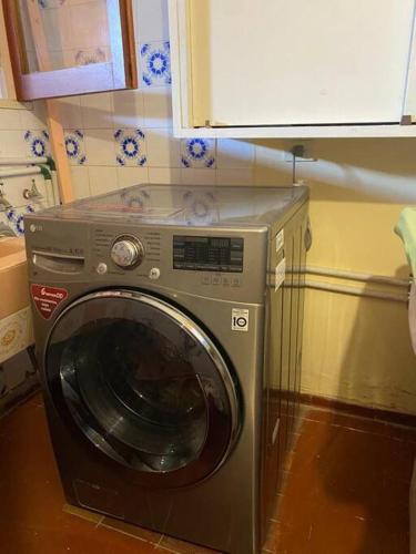 a washing machine in a kitchen next to a cabinet at Casa Tupungato con Churrasquera in Tupungato