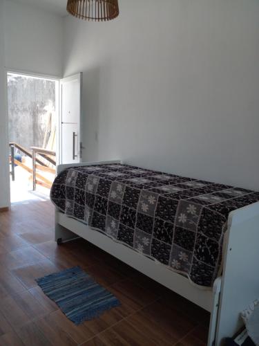 Un dormitorio con una cama con una manta. en Luminoso y bello departamento en Carlos Paz en Villa Carlos Paz