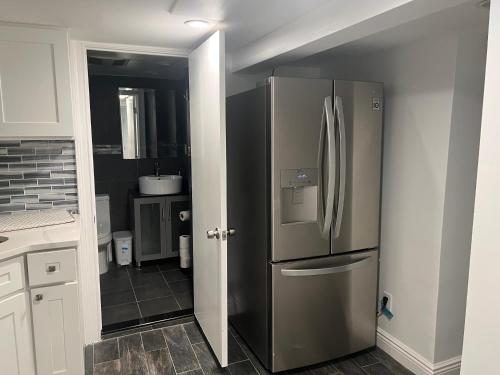 a kitchen with a stainless steel refrigerator in a room at Modern & cozy Room in Queens near Train station and buses in Woodhaven