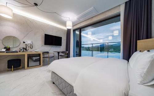 a bedroom with a large white bed and a desk at The Line Hotel in Yangpyeong