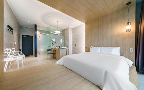 a bedroom with a large white bed and a desk at The Line Hotel in Yangpyeong