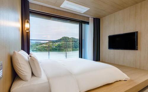 a bedroom with a large bed with a large window at The Line Hotel in Yangpyeong
