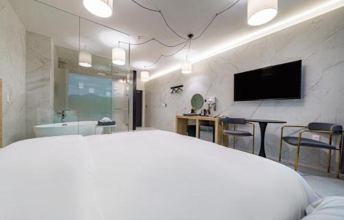 a bedroom with a bed and a tv and a bathroom at The Line Hotel in Yangpyeong