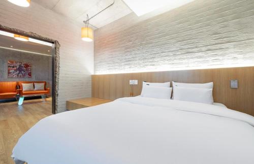 a bedroom with a large white bed and a chair at The Line Hotel in Yangpyeong