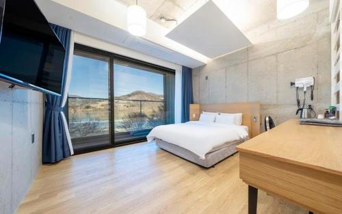 a bedroom with a bed and a large window at The Line Hotel in Yangpyeong