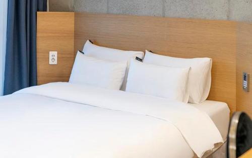 two beds with white pillows in a hotel room at The Line Hotel in Yangpyeong