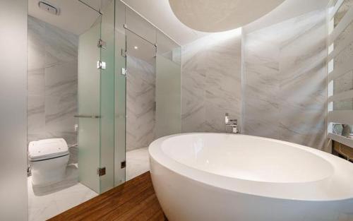 a bathroom with a white tub and a toilet at The Line Hotel in Yangpyeong