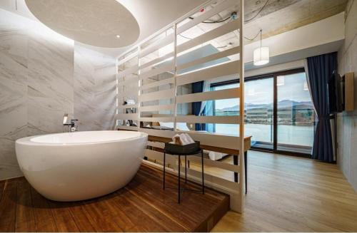 a bathroom with a white tub and a large window at The Line Hotel in Yangpyeong