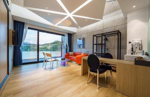 a living room with a couch and a table and chairs at The Line Hotel in Yangpyeong