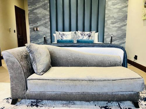 a bedroom with a bed and a couch next to a bed at One O Eight Boutique Hotel in Benoni