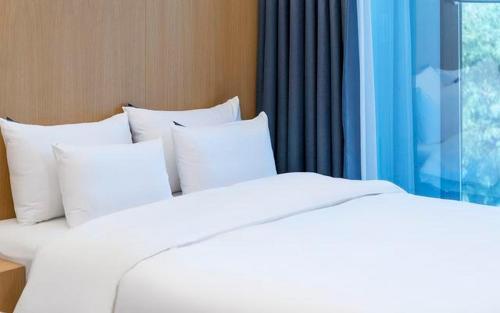 two white beds in a room with a window at The Line Hotel in Yangpyeong