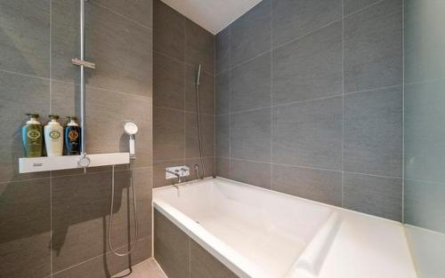 a bathroom with a bath tub and a shower at The Line Hotel in Yangpyeong